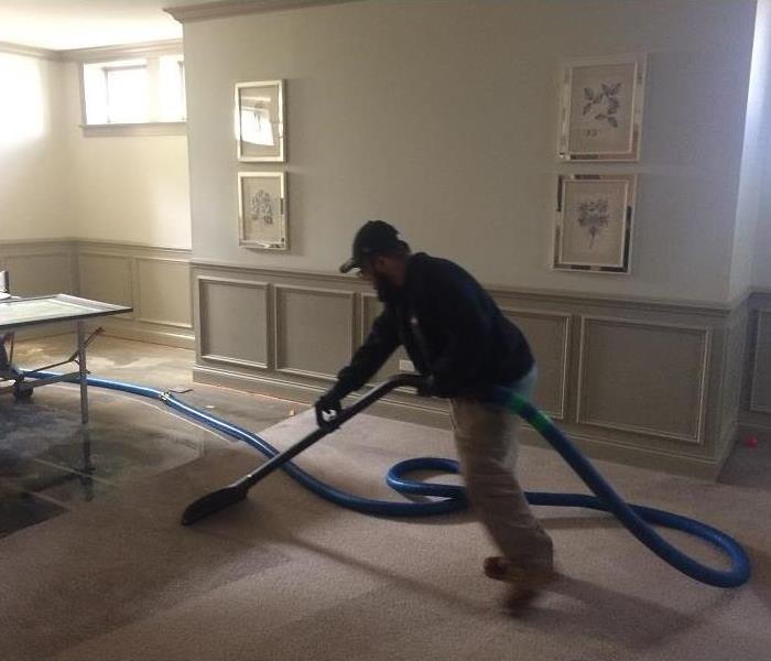 A SERVPRO crew member extracting a wet carpet