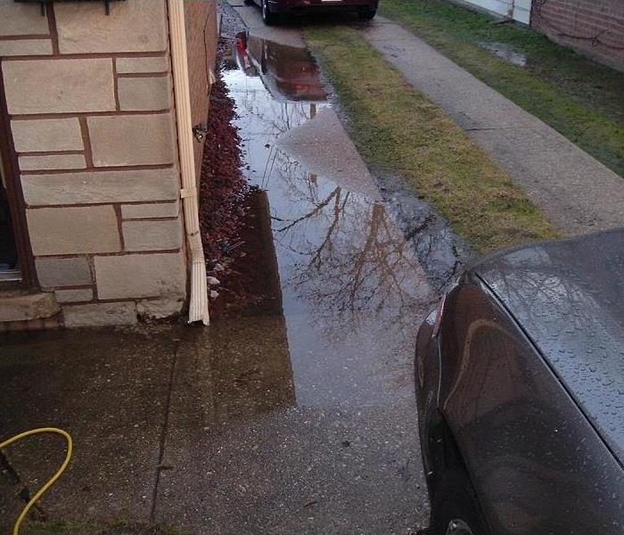 Large puddles of water next to a house's foundation