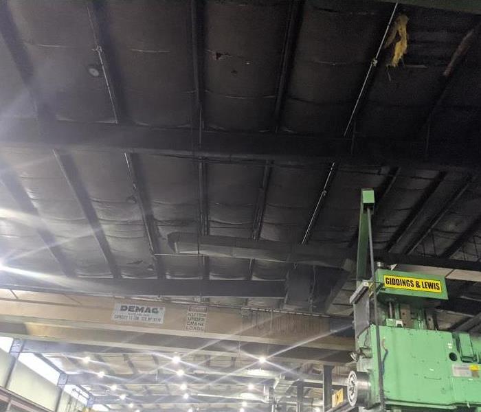 A smoke and soot damaged warehouse ceiling