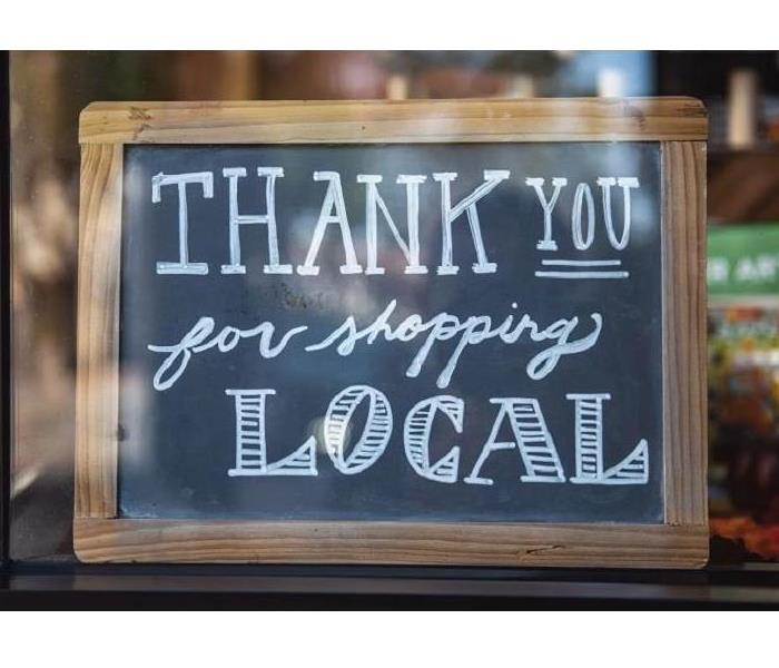 A sign urging customers to buy and shop local
