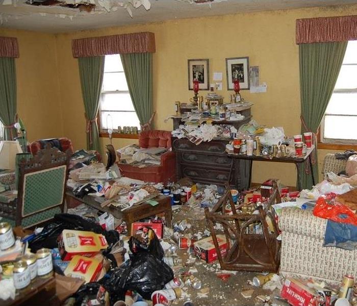 A living room with beer cans and garbage strewn all over