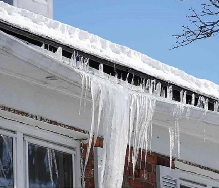 Melting snow flowing over an ice-filled gutter