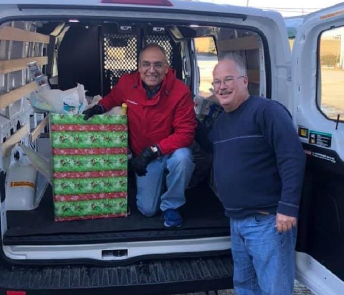 Bridgeview Chamber President and SERVPRO CSR pose in a van with donations.