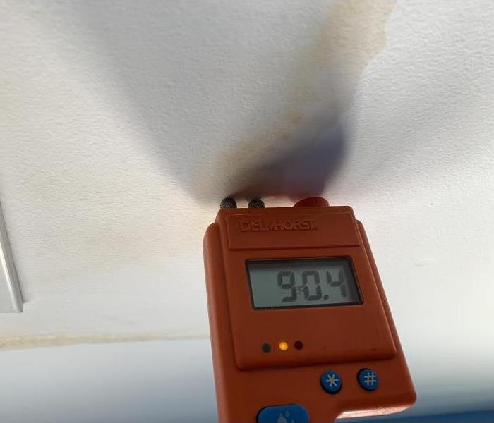 A meter showing water damage inside a ceiling